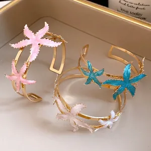 Elegant gold-plated open cuff bangles featuring colorful enamel starfish charms set