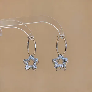 Vue détaillée des boucles d'oreilles créoles avec pendentifs étoile en cristal