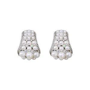 Eleganti orecchini vintage con grappolo di perle e zirconi su sfondo bianco puro