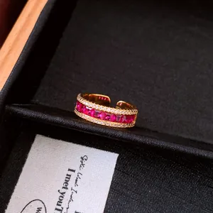 Close-up of retro style gold ring with ruby red zircons and sparkling crystals
