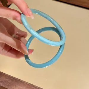 Dettaglio ravvicinato di un braccialetto a cerchio chiuso blu cielo riflesso nello specchio