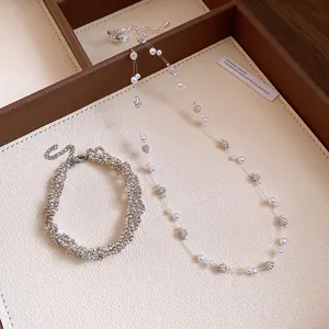 Detailed view of elegant pearl and rhinestone necklace with matching sparkling bracelet set