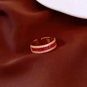 Macro view of a vintage gold-plated open ring featuring red rectangular zircon stones