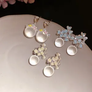 Vue détaillée de boucles d'oreilles fleuries avec pierres translucides style pierre de lune