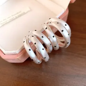 Detailansicht französischer C-Ohrringe, gebürstetes Silber mit schwarzen Punkten.