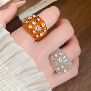 Detailed view of brown and grey resin rings with sparkling rhinestone embellishments.