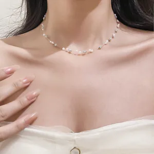 Close-up of a delicate pearl and rhinestone beaded choker necklace worn on model's neck