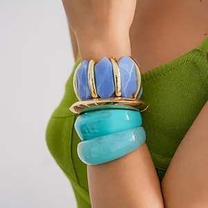 Detailed view of chunky acrylic geometric bangles and blue diamond elastic bracelet