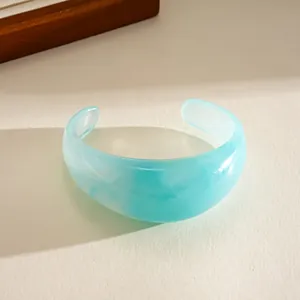 Close-up of a light blue translucent acrylic cuff bracelet with unique marble texture
