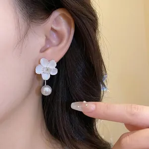French vintage flower earrings with pearl pendant and diamond accents on model ear