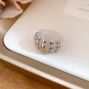 Detailed macro shot of a stylish cream resin dome ring featuring silver metallic studs