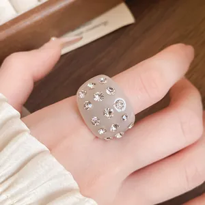 Detailed view of a thick beige resin ring inlaid with sparkling round crystal rhinestones