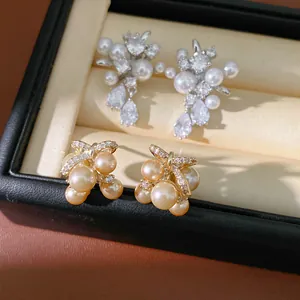 Dettaglio macro di orecchini di perle in argento e oro con zirconi scintillanti in confezione