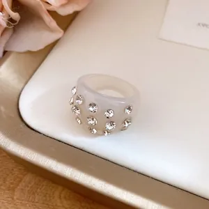 Close-up of cream resin ring with sparkling rhinestone accents on a white tray