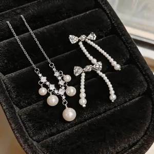 Elegante Silberne Zirkonia-Schleifen-Ohrringe mit Perlenquasten in schwarzer Box.