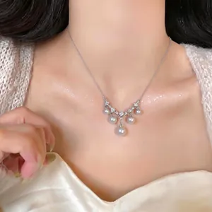 Elegante silberne Halskette mit hängenden weißen Perlen und funkelnden Zirkoniasteinen