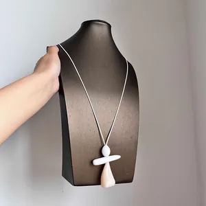 Dettaglio di una collana con pendente geometrico irregolare moderno su un espositore.