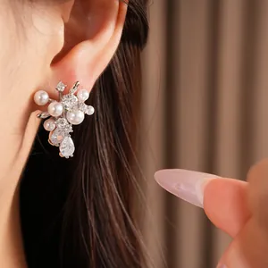 Dettaglio ravvicinato di eleganti orecchini in argento con perle e zirconi a goccia