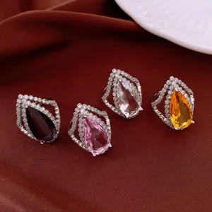Vintage-Zirkonia-Ringe in Tropfenform in verschiedenen Farben auf luxuriöser roter Seide.