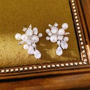 Dettaglio di eleganti orecchini in argento con grappoli di perle e zirconi a goccia scintillanti