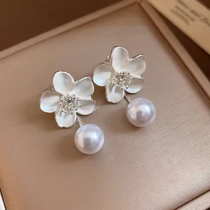 Close-up view of vintage French style flower earrings featuring elegant pearl drops and crystals