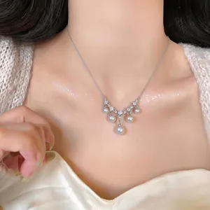 Nahaufnahme einer eleganten Perlen-Fransen-Halskette mit Zirkonia-Akzenten an einem Model.