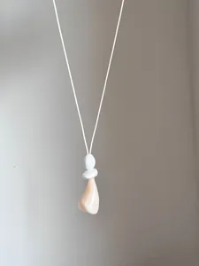 Dettaglio di una collana minimalista in stile coreano con pendente geometrico irregolare.