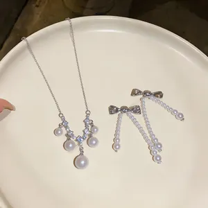 Elegantes Perlen-Schmuckset mit Zirkonia-Halskette und Schleifen-Ohrringen auf Tablett