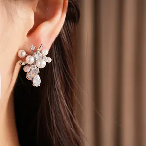 Primo piano di eleganti orecchini in argento con perle bianche e scintillanti zirconi.