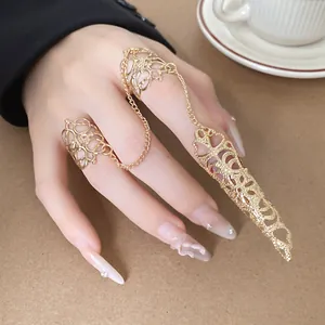 Aufwändige goldene Gothic-Fingerpanzerung und Ring-Set mit Kette an der Hand des Models
