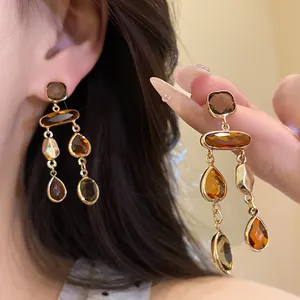 Close-up of vintage Maillard style amber crystal tassel earrings with gold setting