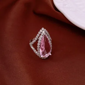 Nahaufnahme eines Vintage-Rings mit rosa Tropfen-Zirkonia auf braunem Stoffhintergrund.