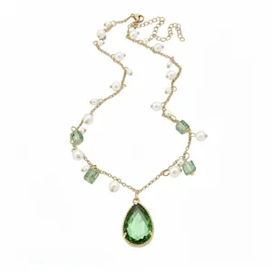 Vintage gold necklace with green pear pendant and white pearls on white background