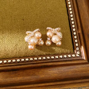 Primo piano dettagliato degli orecchini a fiocco con zirconi e perle rosa eleganti