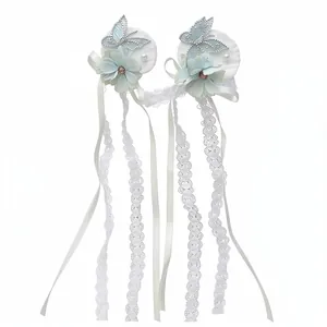 Elegant fabric hair clips with light blue flowers, butterflies, and long white lace tassels.