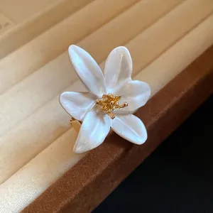 Vintage white oil-dripped flower open ring with gold stamen on a jewelry display tray