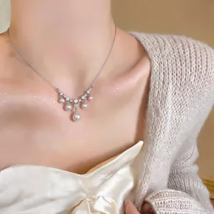 Detailansicht einer eleganten Perlenhalskette mit Zirkonia-Akzenten am Hals.