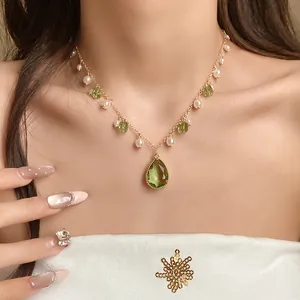 Elegant vintage green gemstone and pearl pendant necklace displayed on model neck