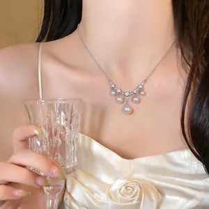 Detailansicht einer eleganten Perlenkette mit glänzenden Zirkonen an einem Modelhals