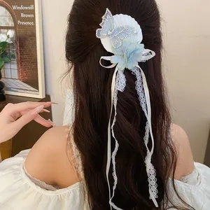 Detail of sweet butterfly and flower hair clip with shell and elegant long lace tassels