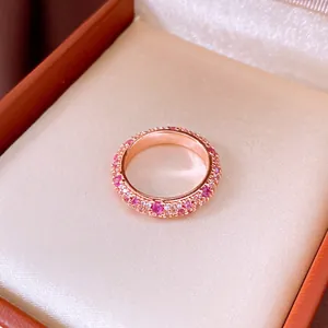 Close-up of a French vintage rose gold ring pave-set with pink and white zircons