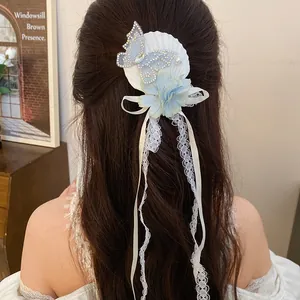 Elegant blue butterfly hair clip with flower and lace tassels on long wavy hair