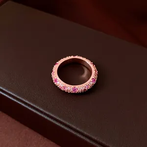 Close-up of retro rose gold ring pavé-set with sparkling pink and white zircons.