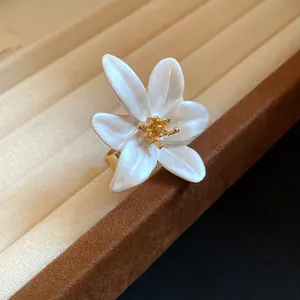 Detailed close-up of a vintage white enamel flower open ring with gold stamen