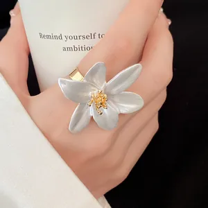 Close-up macro view of vintage enamel flower ring with white petals and gold core