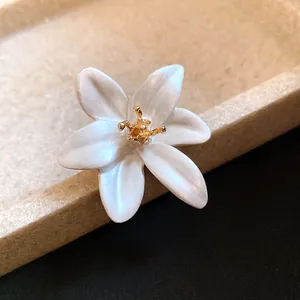 Close-up of a vintage white oil-drop flower open ring with gold stamen detail