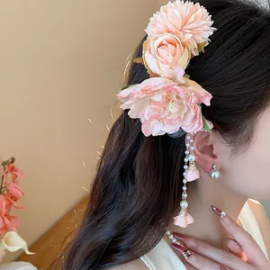 Vue détaillée d'une pince à cheveux fleur rose avec glands en perles