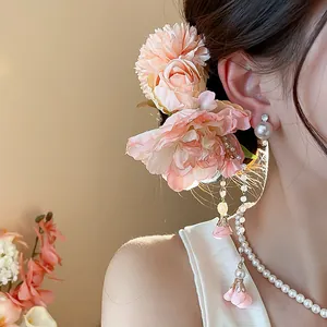 Gros plan sur l'élégante pince à cheveux fleur rose en tissu avec pompons perles
