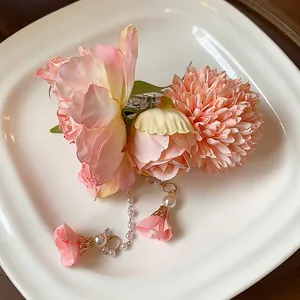 Vue détaillée d'une pince à cheveux à fleurs roses avec perles sur assiette blanche