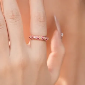 Elegant rose gold pavé ring encrusted with pink and white cubic zirconia on a finger